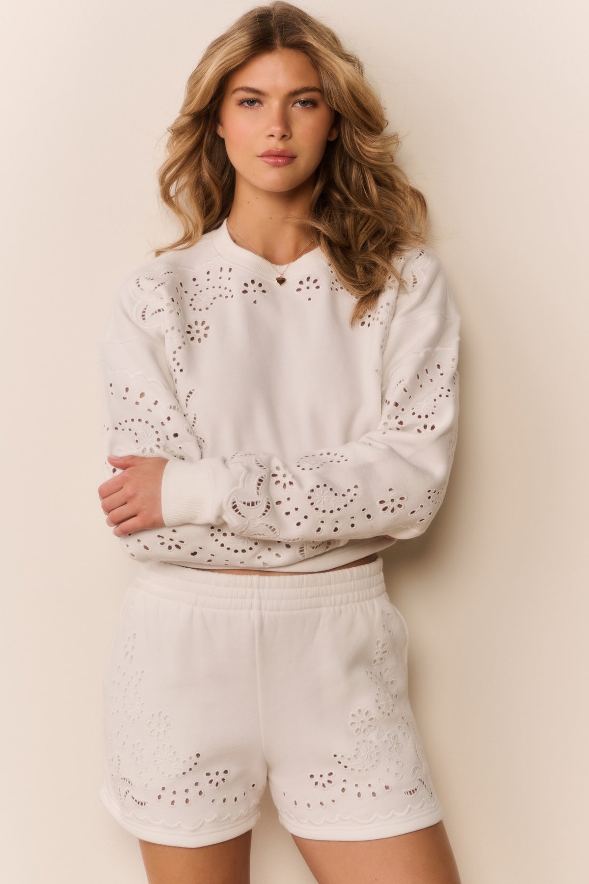 White fleece shorts with eyelet embroidery cutouts, elastic waistband, front view