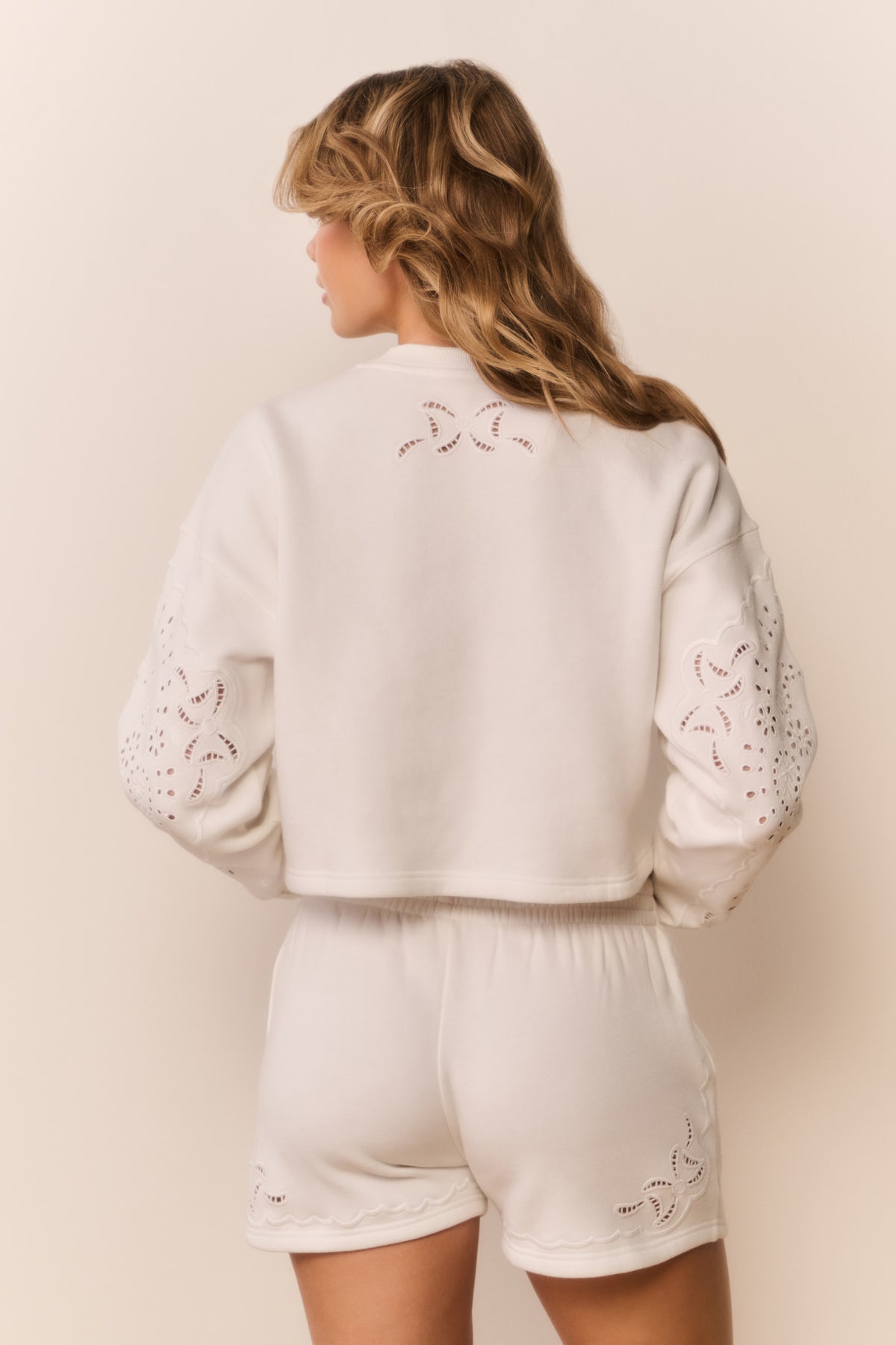 White fleece shorts, back view with eyelet embroidery and elastic waistband