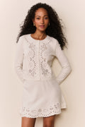 White eyelet knit cardigan with button front and scalloped eyelet hem, front view.
