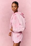 Pink gingham windbreaker shorts with elastic waistband and ruffled hem, side view