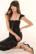 Black lace ruffled-sleeve slip dress, close-up of lace hem and fitted skirt.