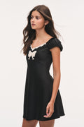Tween Karola black mini dress with white lace bow trim and puff sleeves