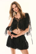 Black lace cropped blouse with sheer fringe sleeves and gold pendant necklace detail