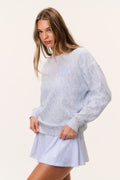 Light blue tennis print pullover with crew neck, long sleeves, side view