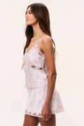 Floral satin camisole top side view, spaghetti straps and lace trim on light blue
