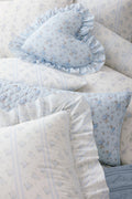Light blue floral ruffle throw pillow with gathered edge trim and soft quilted look