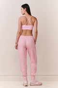 Pink printed cotton sweatpants, back view, elastic cuffs and relaxed tapered legs
