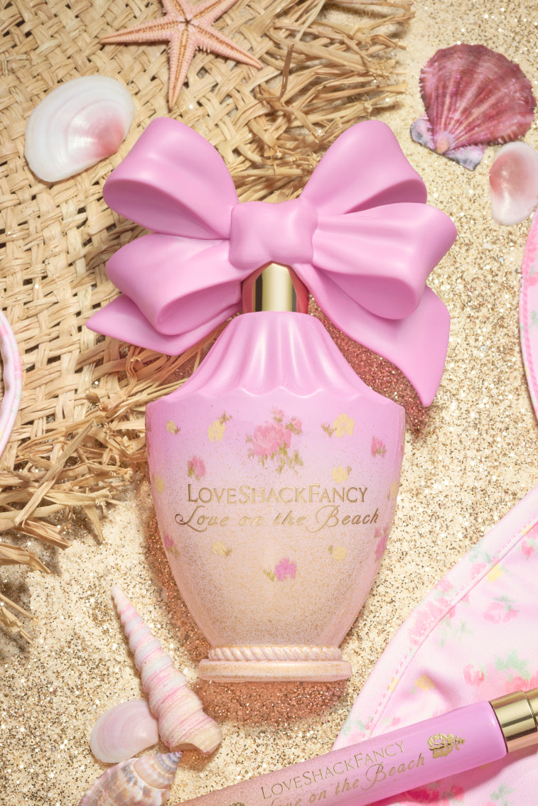 Pink Love on the Beach eau de parfum bottle with large bow on straw and seashells