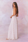 White floral halter maxi dress, standing side view with gathered skirt tiers