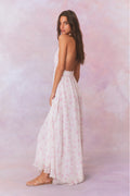 White floral print halter maxi dress, side/back view with flowing tiered skirt