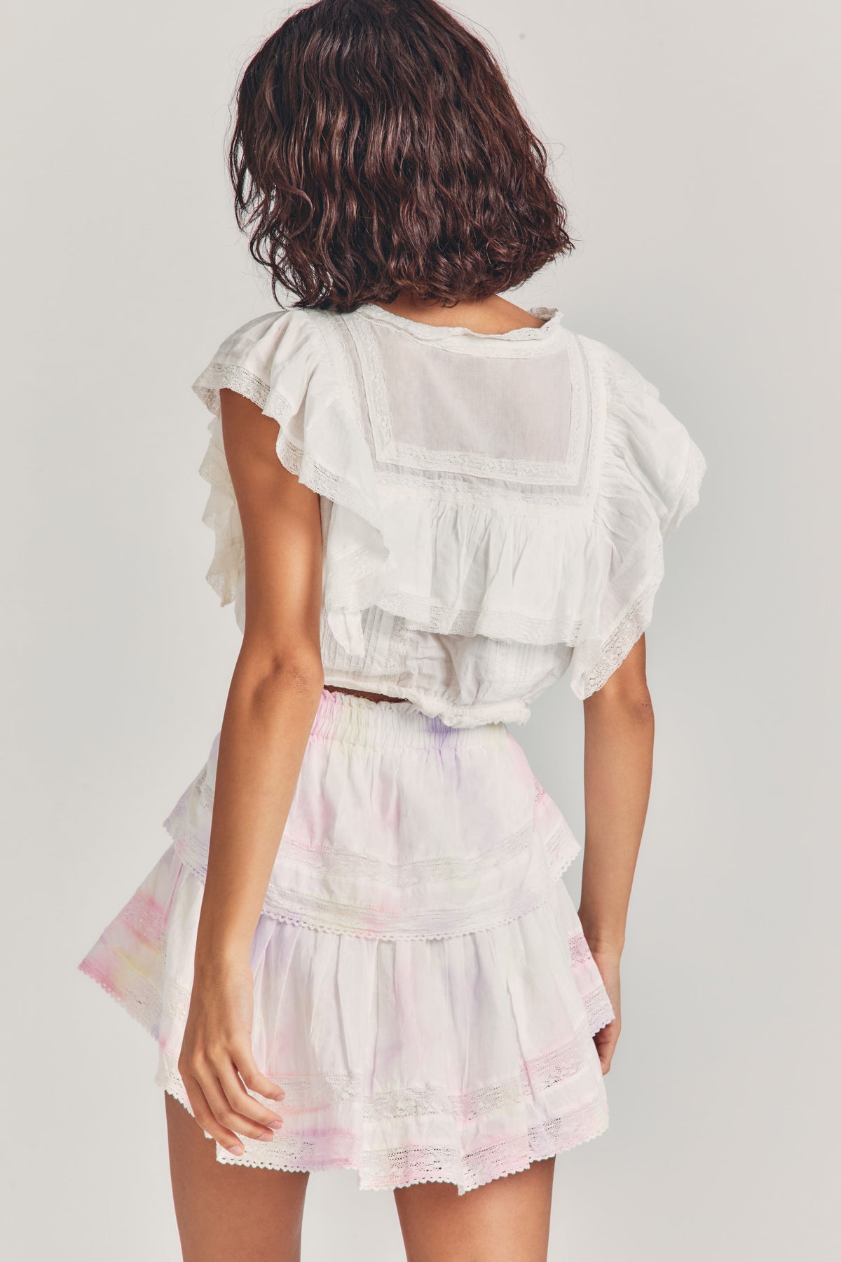 Back view of ruffle mini heritage skirt with gathered waist and tiered pastel ruffles
