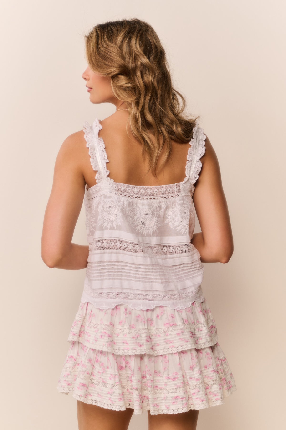 Light pink floral ruffle mini skirt with layered ruffle tiers at hem