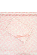 Pink gift wrapping paper featuring a soft bow motif on a floral pattern
