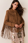 Tan suede fringe jacket with fringed yoke and sleeve tassels over a sequin dress.