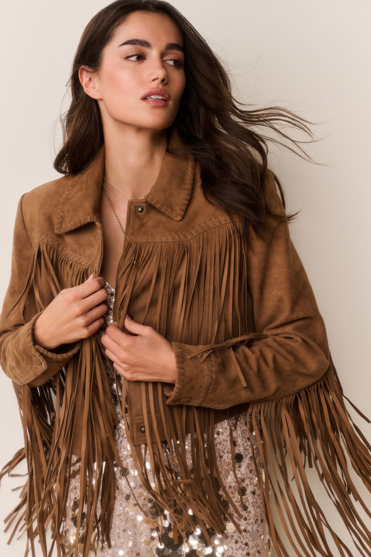 Tan suede fringe jacket with pointed collar and tassel fringe across chest and sleeves.