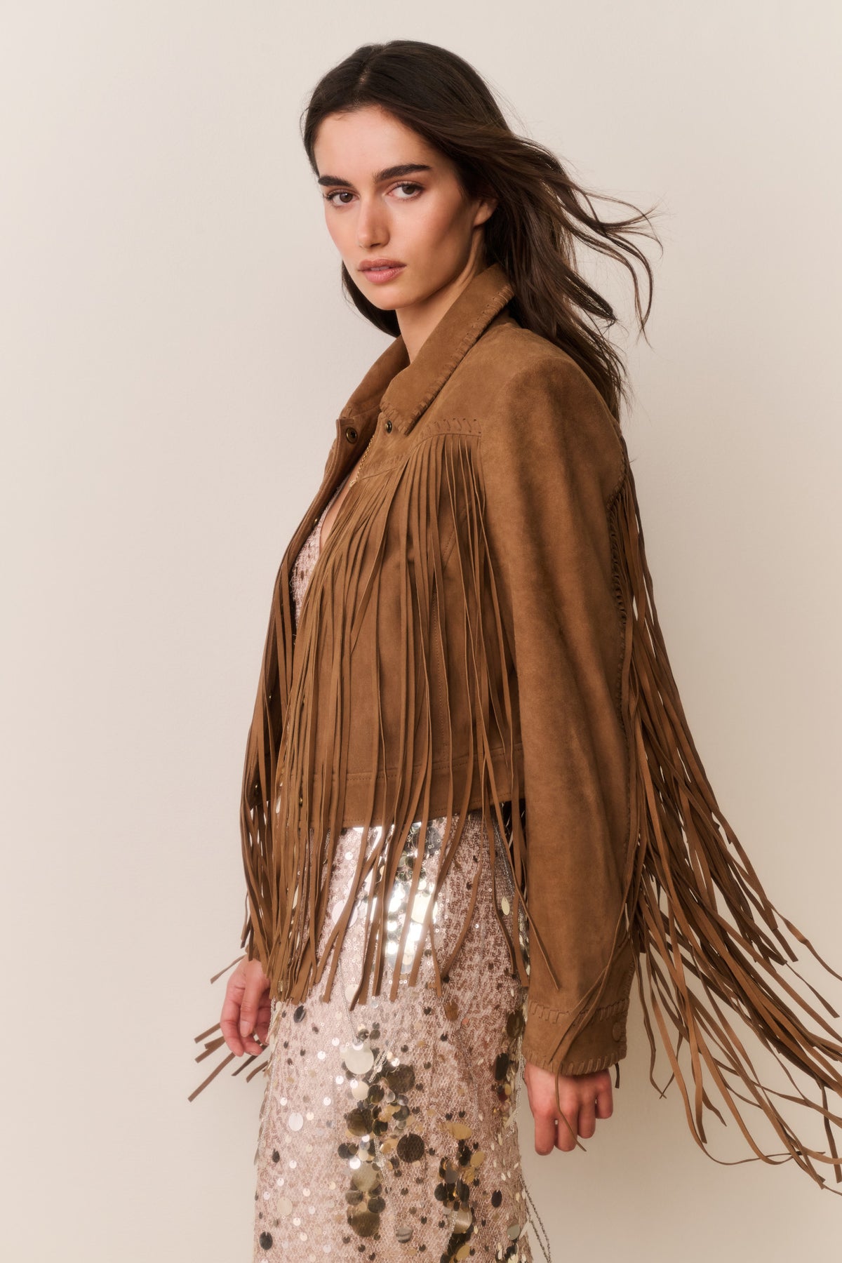 Tan suede fringe jacket with shoulder and sleeve fringe details and buttoned front.