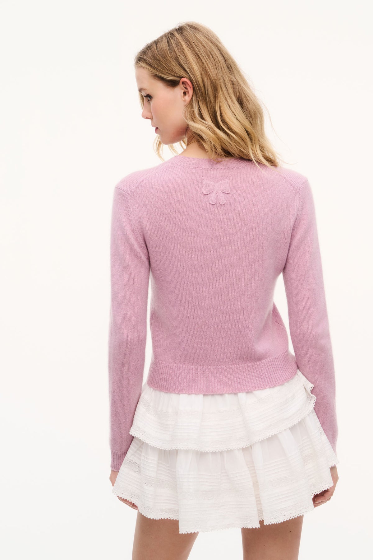 Back view of dusty rose fitted cashmere pullover with small bow detail at neckline