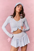 Light blue printed zip-up active top with V-neck, ruched front zipper, and ruffled hem