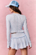 Light blue printed zip-up active top, long sleeves, open back, and ruffled peplum hem