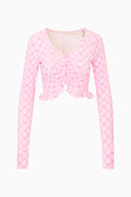 Pink printed zip-up active top with V-neck, long sleeves, and ruffled hem