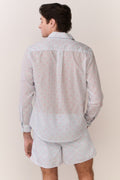 Men's swim shorts with light base and small red-and-blue print, rear view