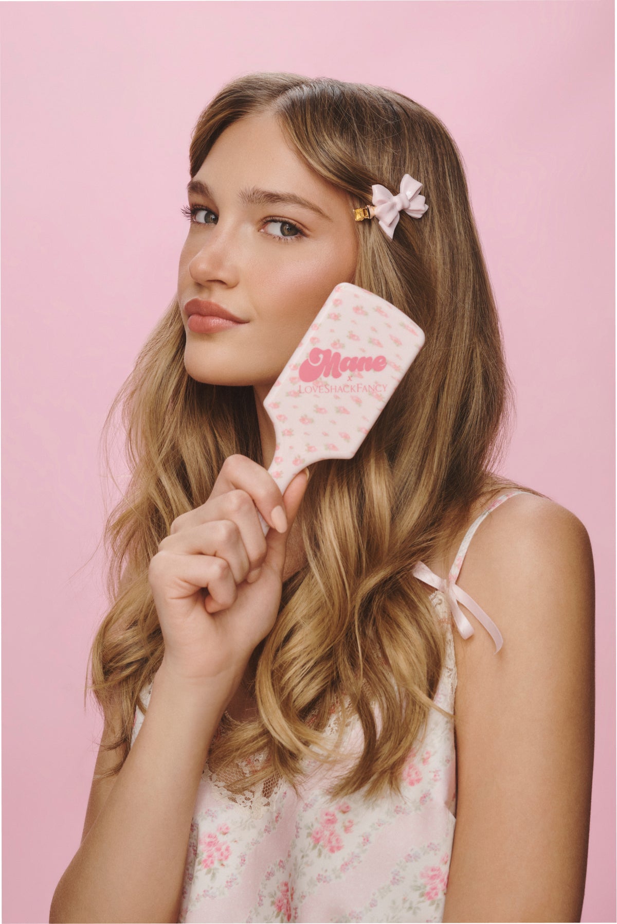 Pink floral mini detangling brush with logo text on white handle