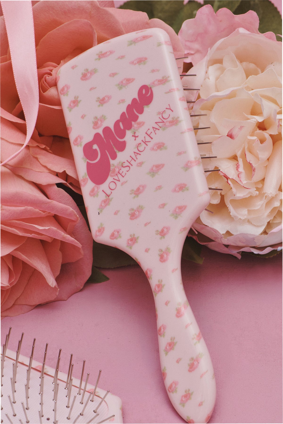 Pink mini detangling hair brush with floral print handle and metal pins