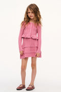 Girls pink pointelle cardigan with button front, worn over tiered ruffled skirt