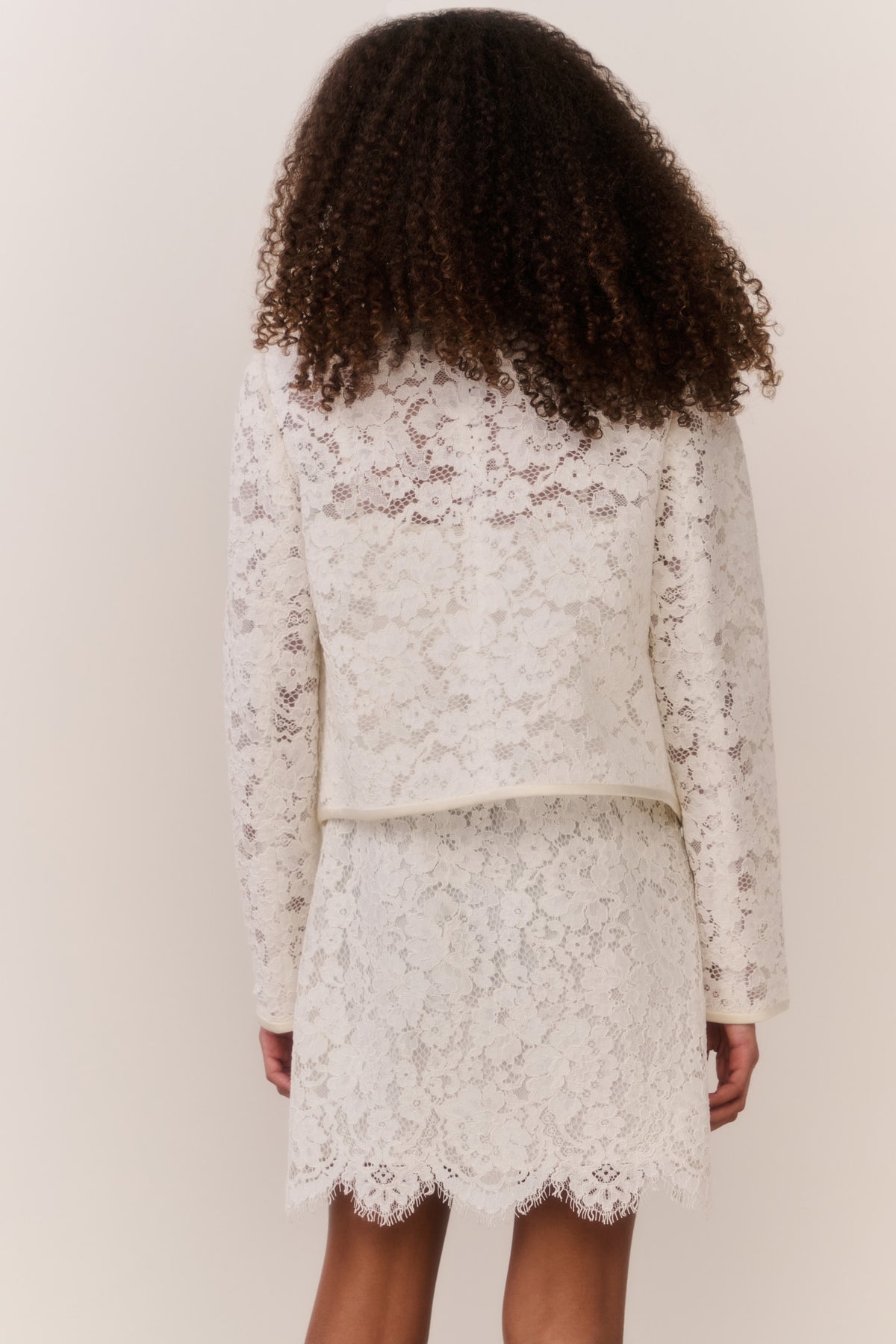 Ivory lace jacket back view with scalloped hem and fitted waist