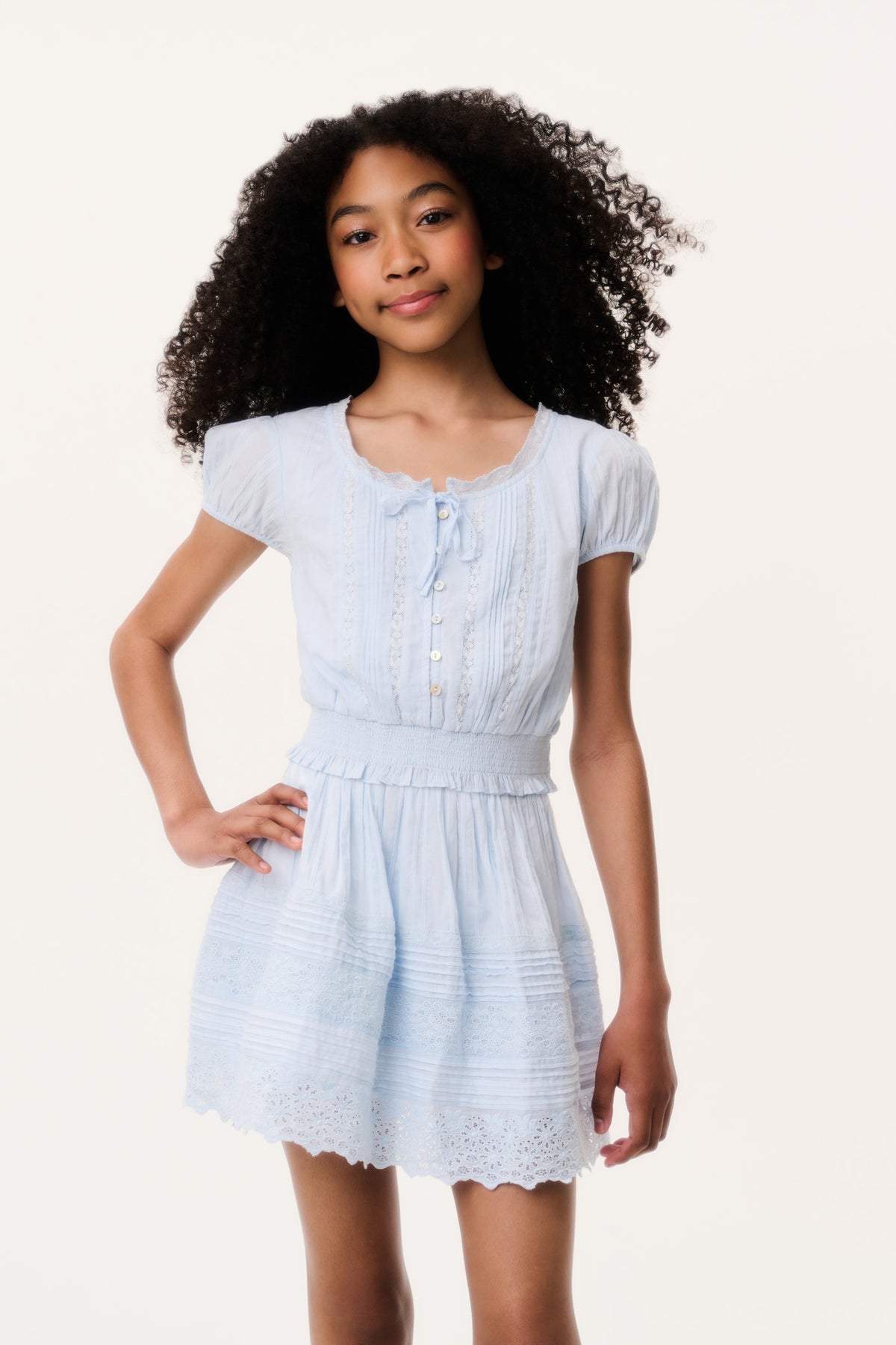 Light blue tween cotton top with puff sleeves, front buttons, and tiered skirt