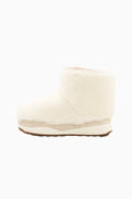 Off-white girls ankle boot with plush upper and brown outsole edge