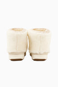 Pair of off-white faux-fur girls boots with rounded cuffs and brown rubber soles