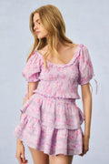 Pink printed peplum top with puff sleeves, smocked bodice, and ruffled tiers