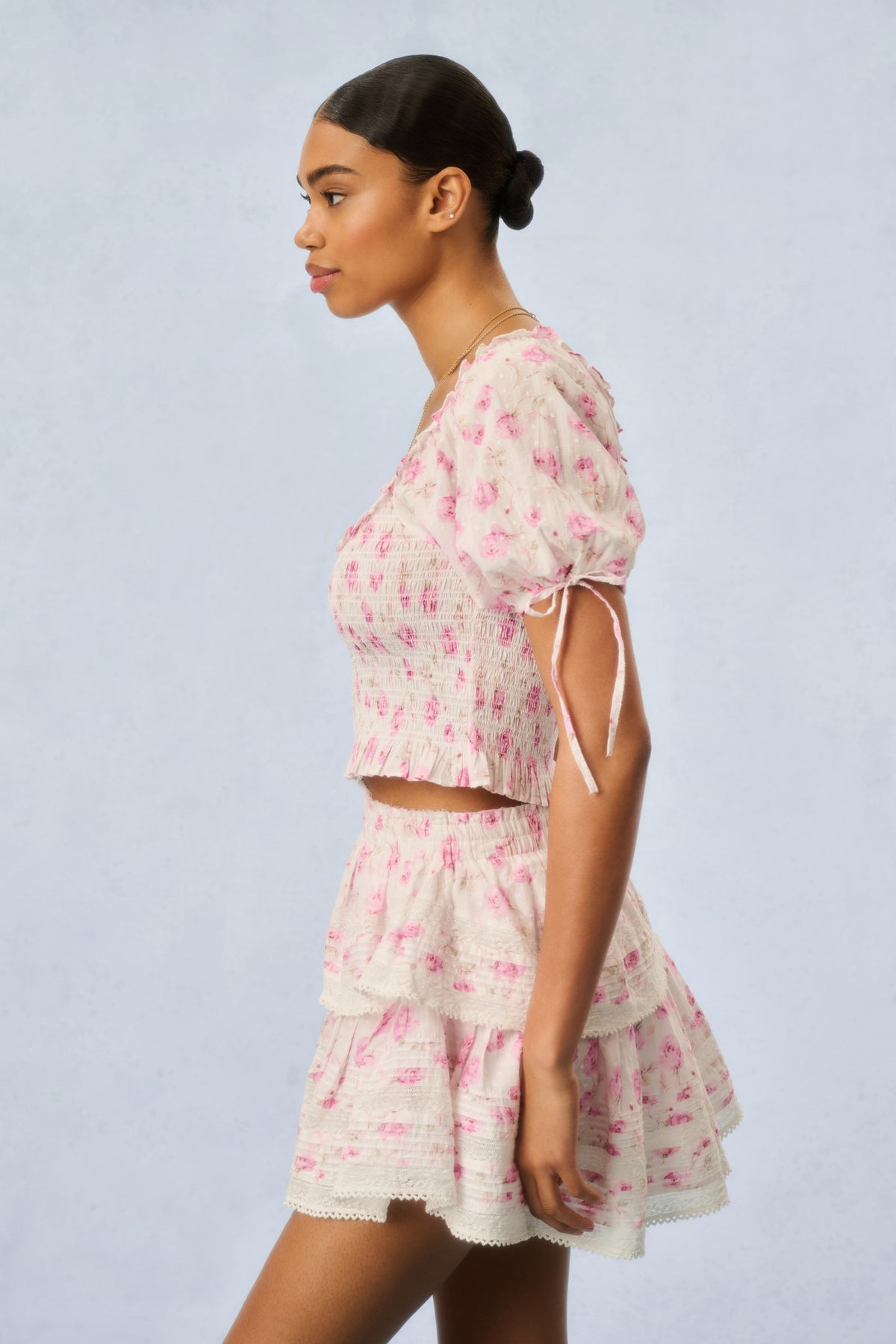 Pink floral print tiered mini dress, side view with smocked waist and puff sleeves
