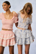Printed puff-sleeve peplum tops in pink and light blue, smocked bodice and tiers