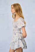 Blue floral print tiered mini dress, side view with smocked bodice and puff sleeves