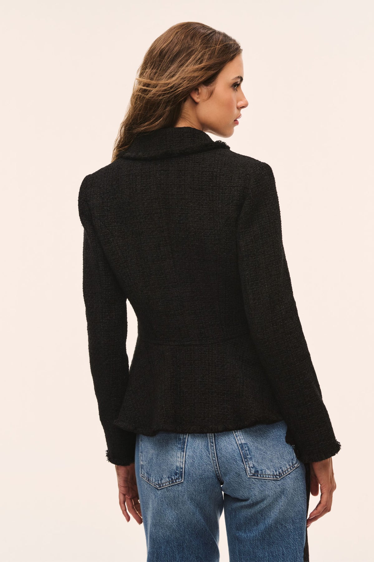 Black tweed peplum jacket back view with long sleeves and fitted waist