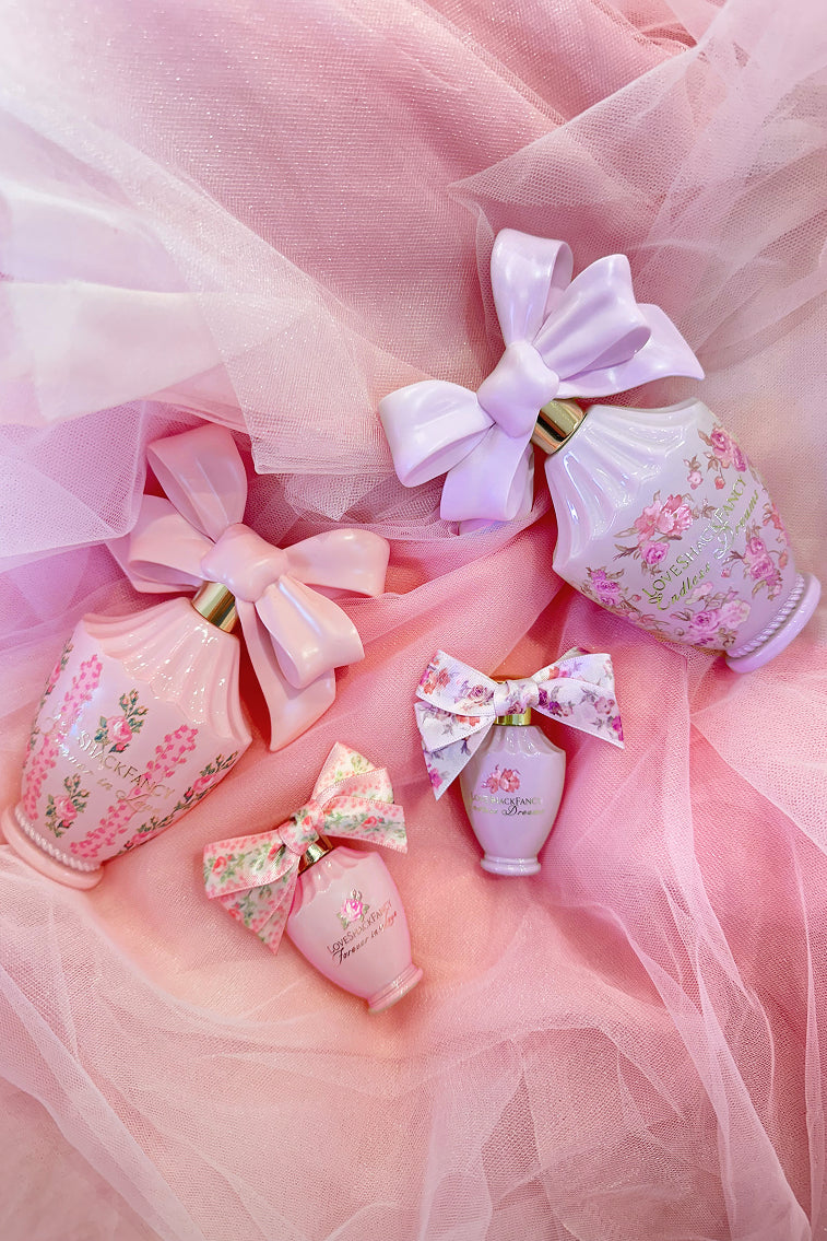 LoveShackFancy mini eau de parfum set with multiple ribbon bottles on soft tulle