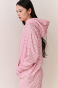 Pink cotton hoodie with hood and drawstring, side view with dropped shoulder, long sleeves