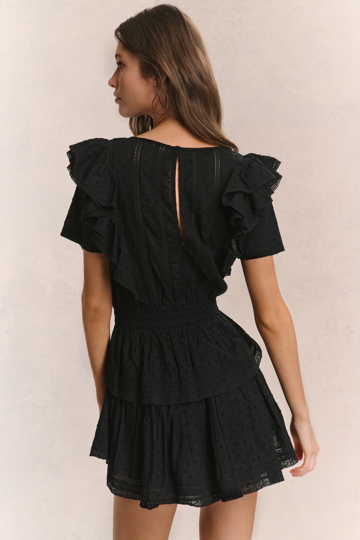 Black mini dress back view with tiered skirt and flutter sleeves
