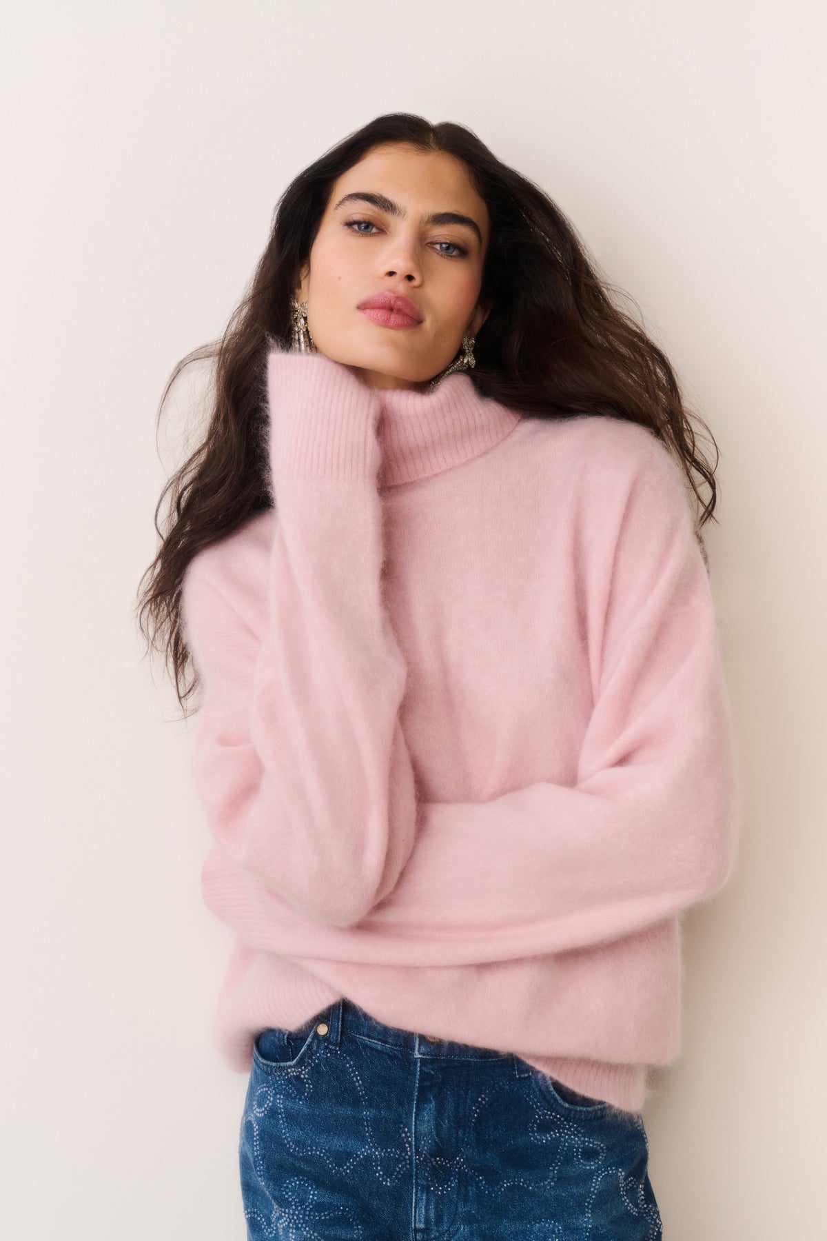 Pink cashmere turtleneck sweater worn with long sleeves