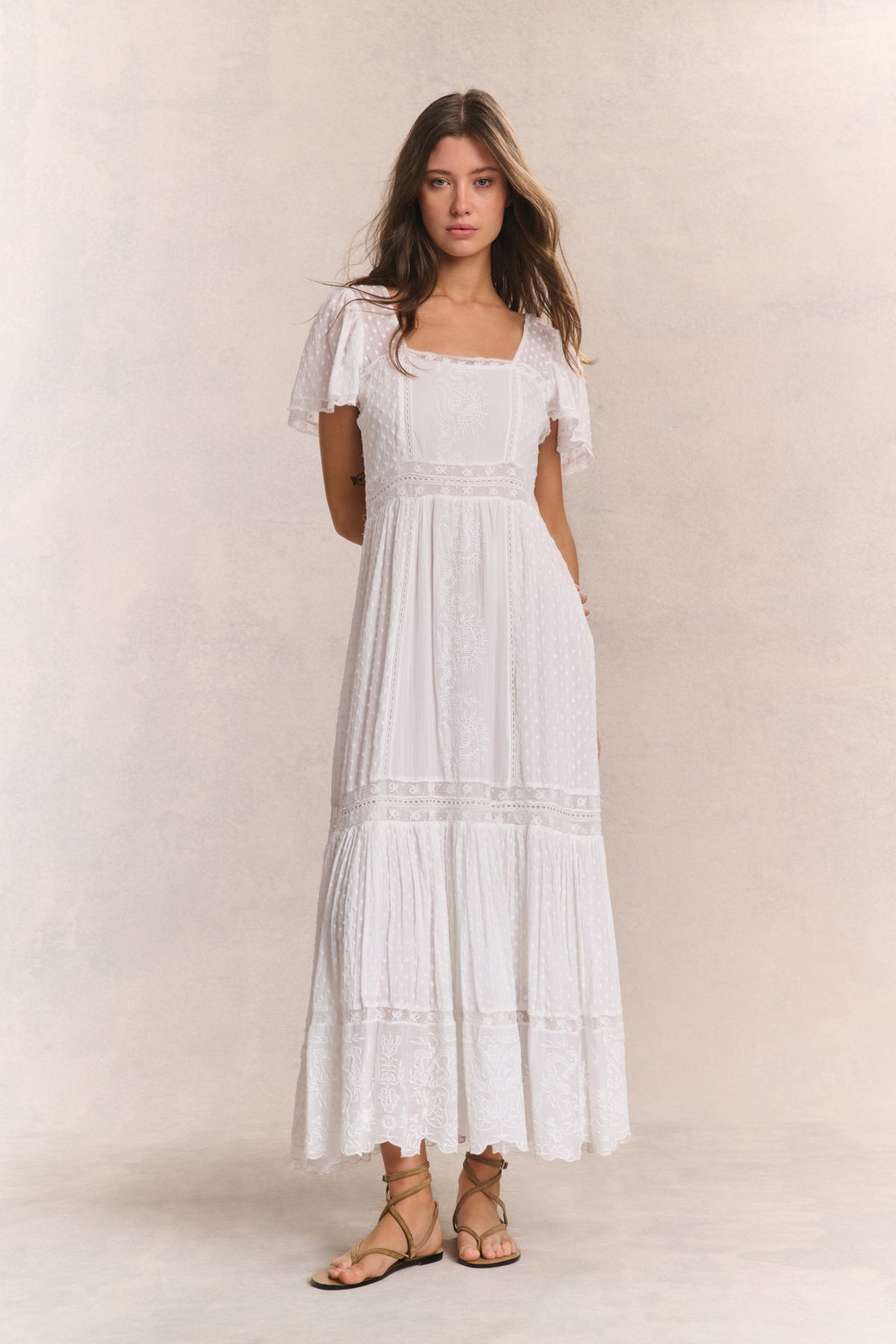 White maxi dress with square neck, lace yoke, and tiered skirt with short sleeves