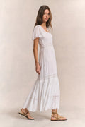 White tiered maxi dress with square neck, lace panel details, and short puff sleeves