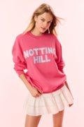 Hot pink pullover sweatshirt with large 'NOTTING HILL' graphic (front)