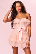 Strapless rose tulle mini dress with layered ruffles and satin bow, close-up view