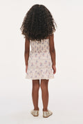 Back view of girls nune dress in antique vanilla, gathered bodice and tiered ruffle skirt.