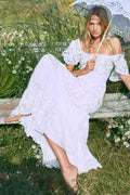 White tiered maxi dress with square neckline, lace trim, and short puff sleeves
