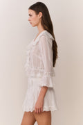 White Victorian mini skirt with tiered ruffle layers and lace-trim hem, side view