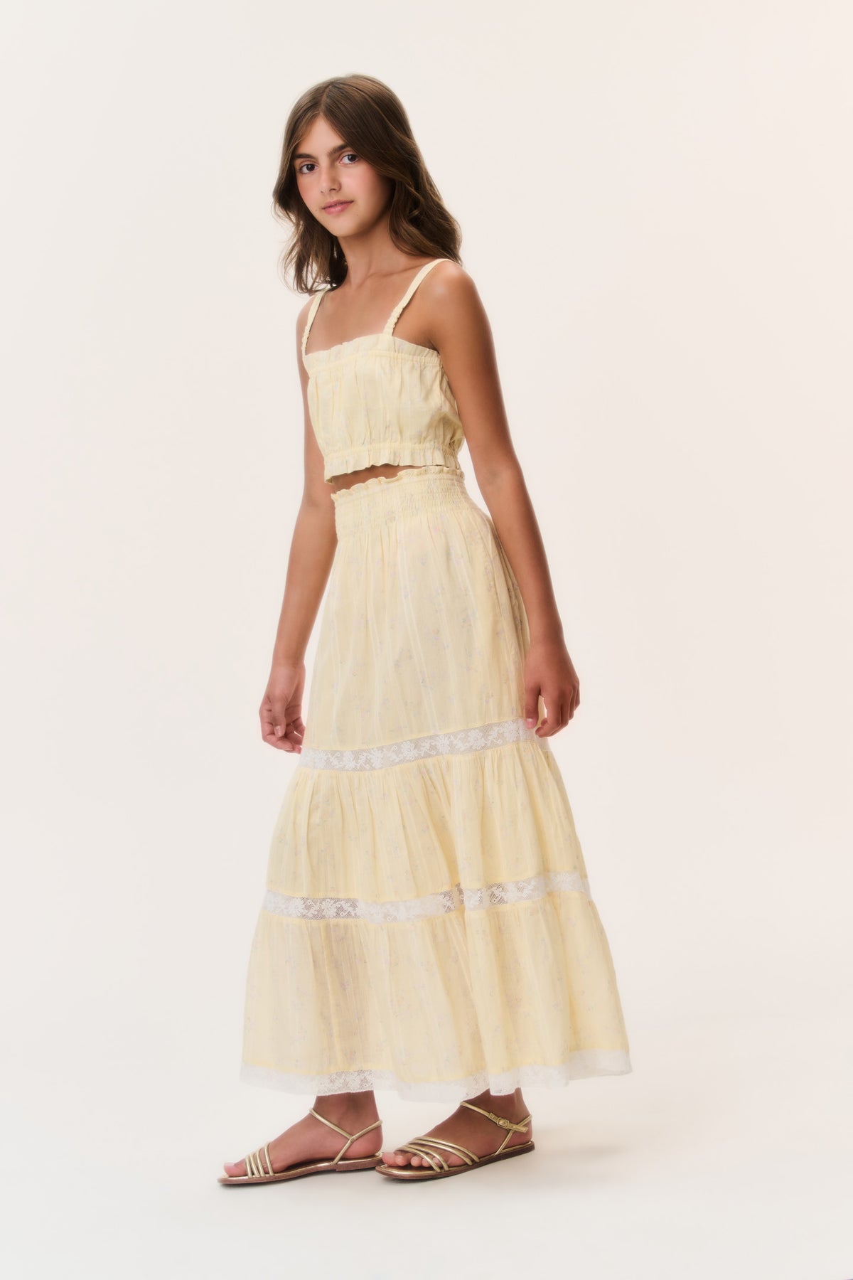 Light yellow tiered tween skirt with lace trim and flowing tiered hem