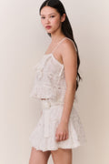 Floral embroidered cotton mini skirt with tiered ruffles and gathered waist (side view).
